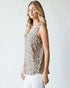 Woman wearing a sleeveless animal print top against a plain background