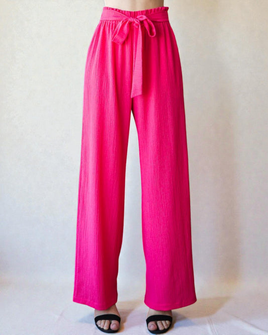 Hot pink wide-leg pants with a tie waist on a white background