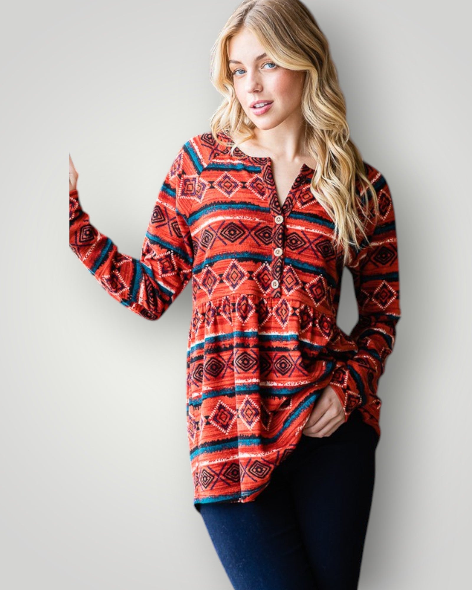 Woman wearing a red patterned long-sleeve shirt against a plain background