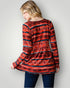 Person wearing a red patterned sweater against a plain background