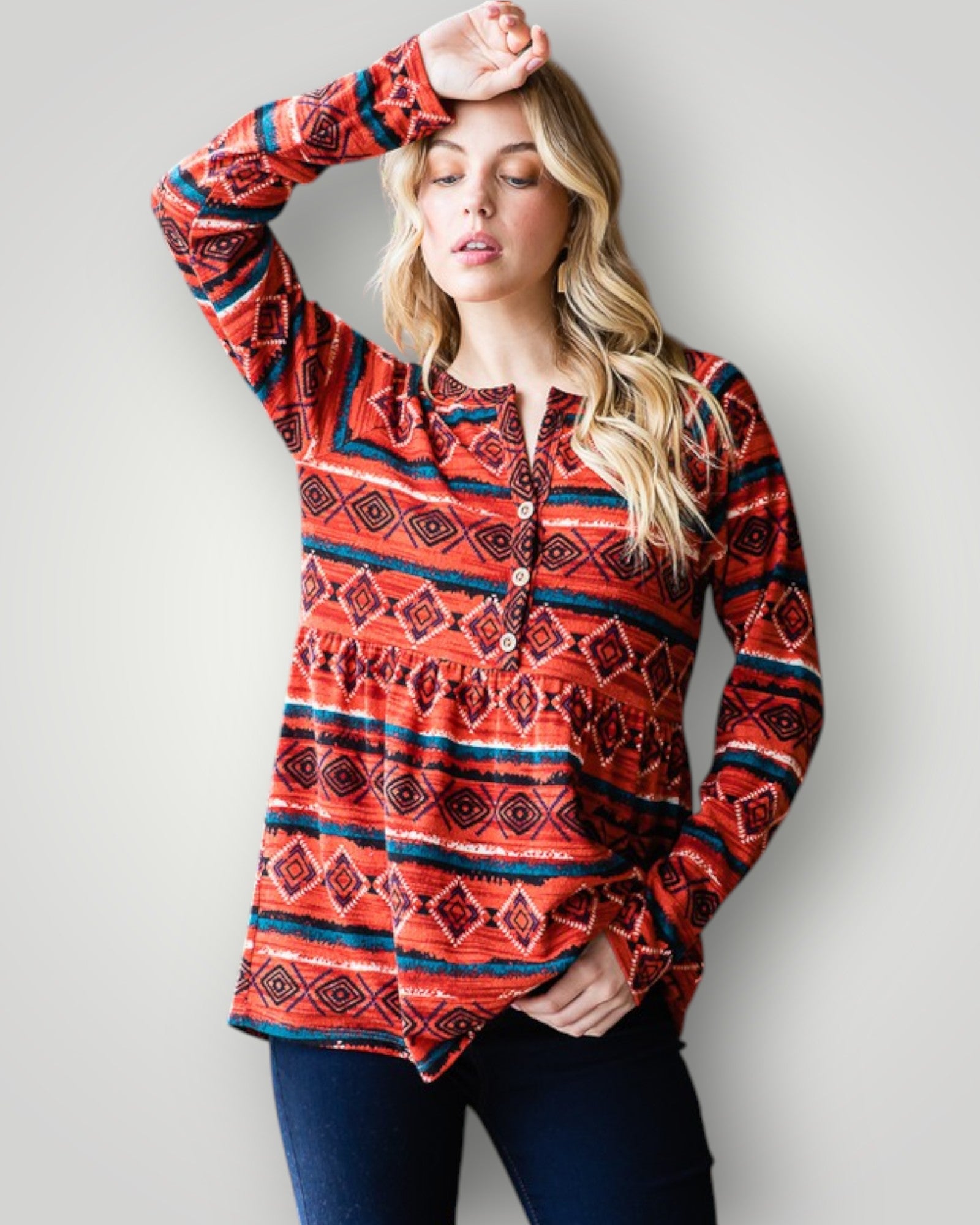 Woman wearing a red patterned long-sleeve shirt against a light gray background