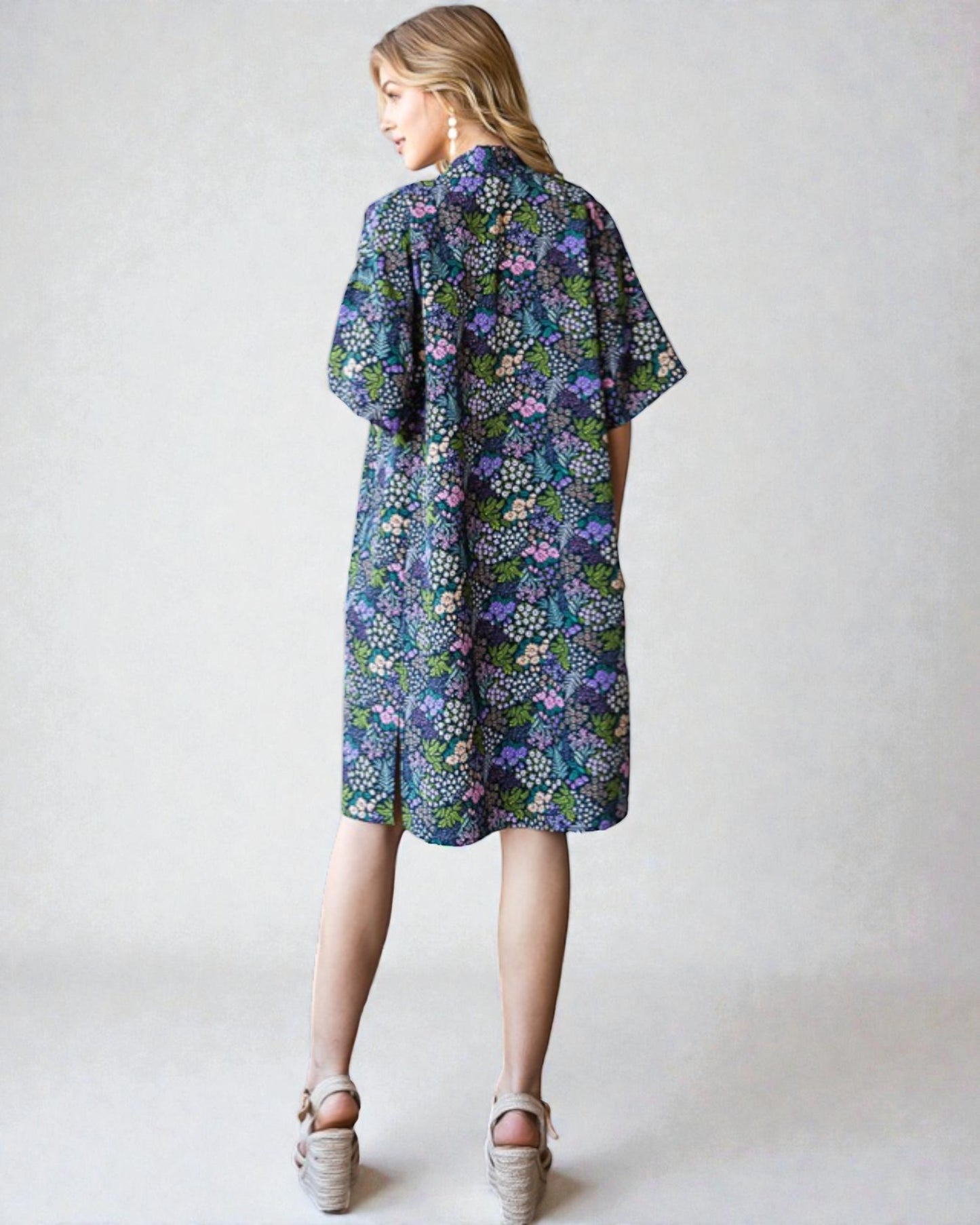 Woman wearing a floral dress on a plain background
