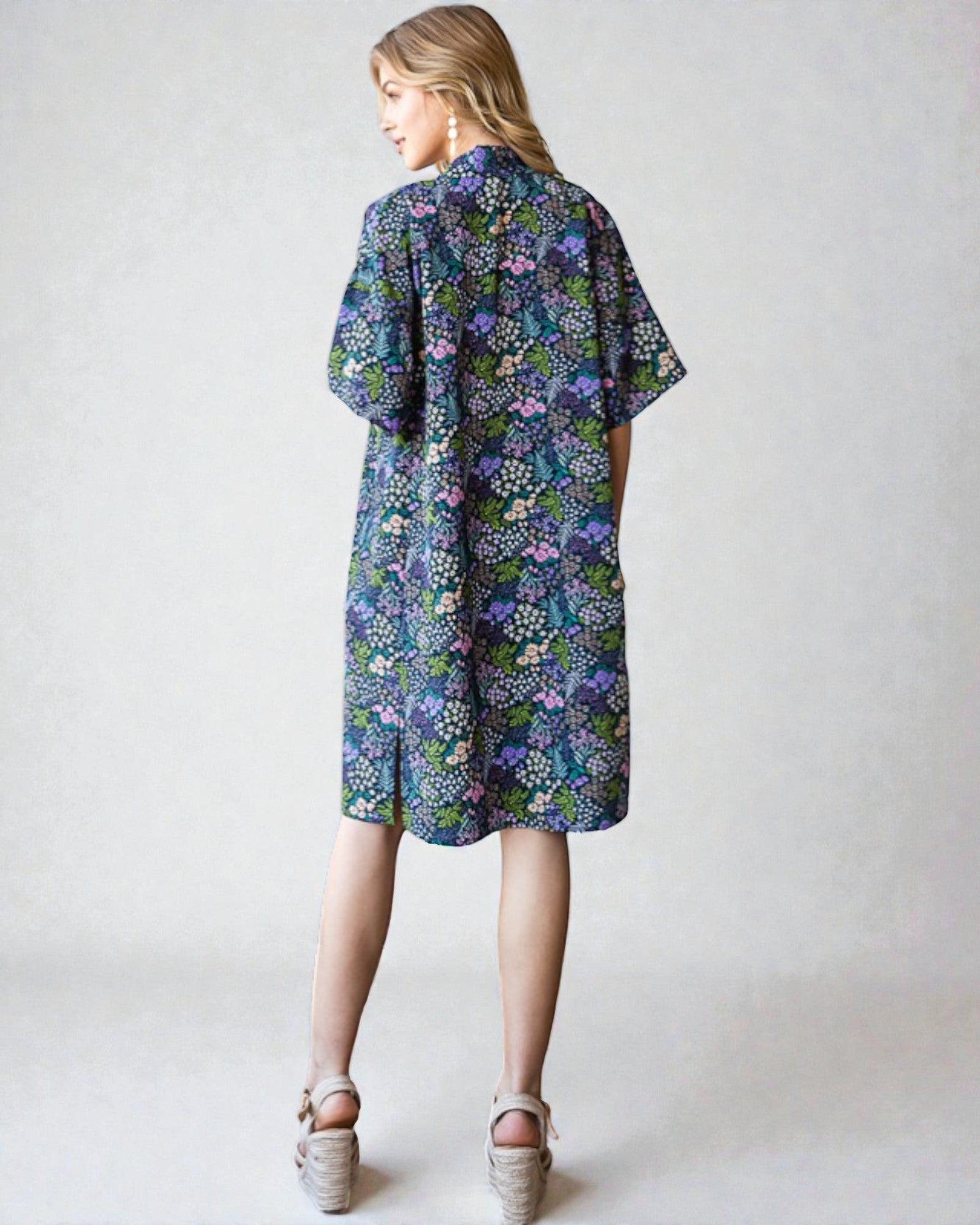Woman wearing a floral dress on a plain background