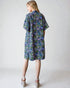 Woman wearing a floral dress on a plain background