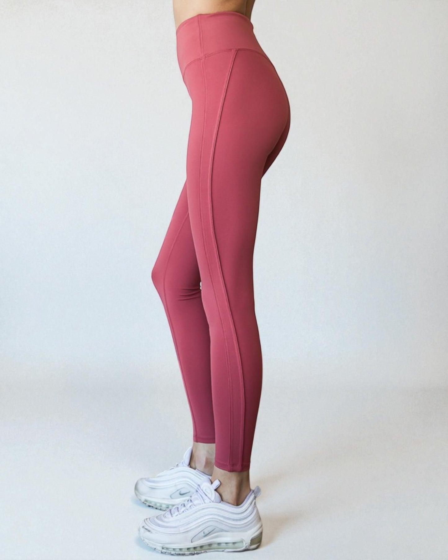 Pink leggings worn by a person on a white background