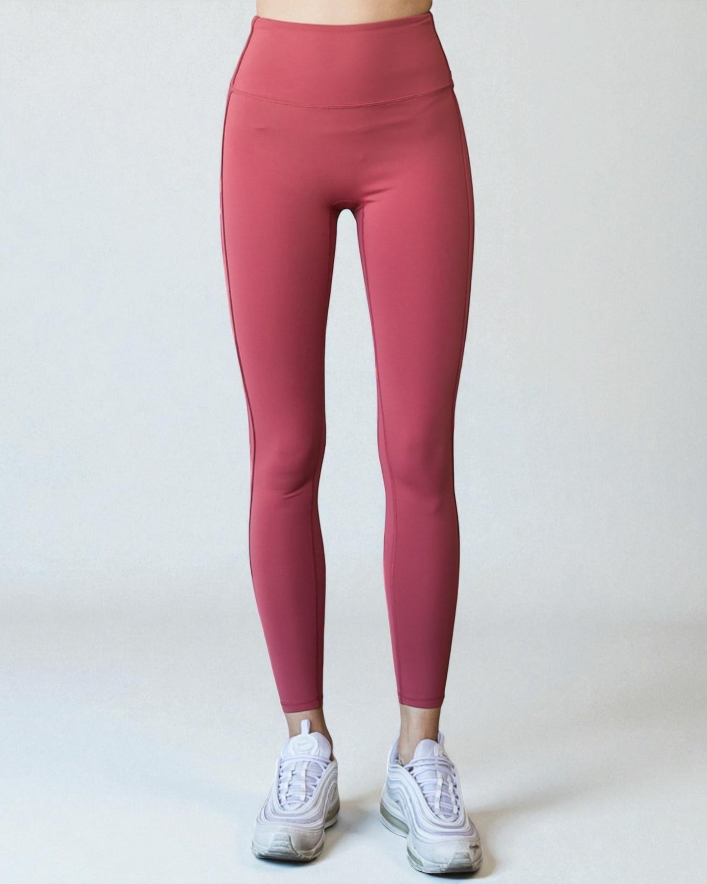 Person wearing pink leggings on a white background