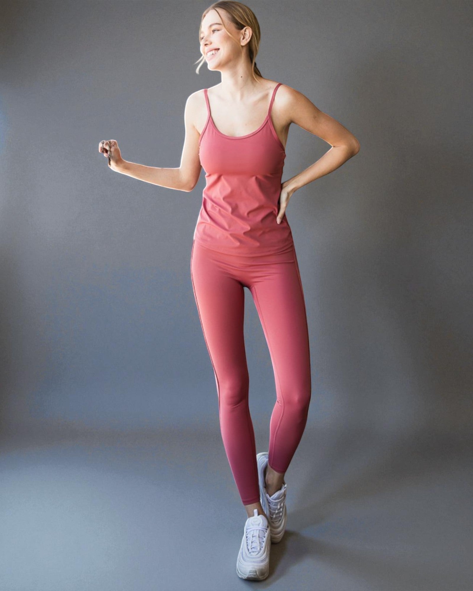 Woman wearing a pink athletic outfit on a gray background