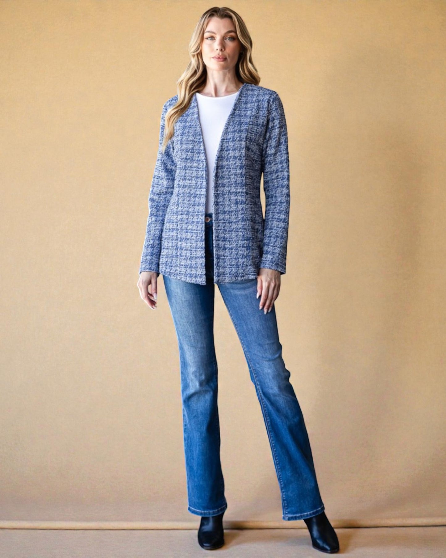 Woman wearing a blue checkered jacket and jeans against a beige background