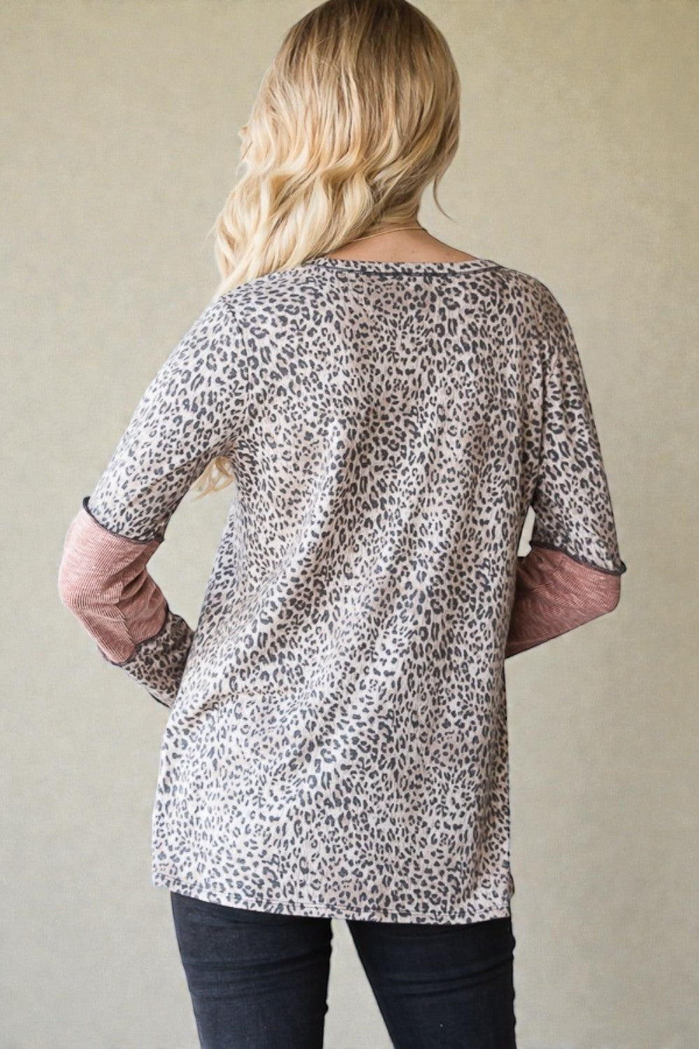 Woman wearing a leopard print top against a plain background