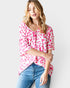 Woman wearing a pink leopard print top and blue jeans on a white background
