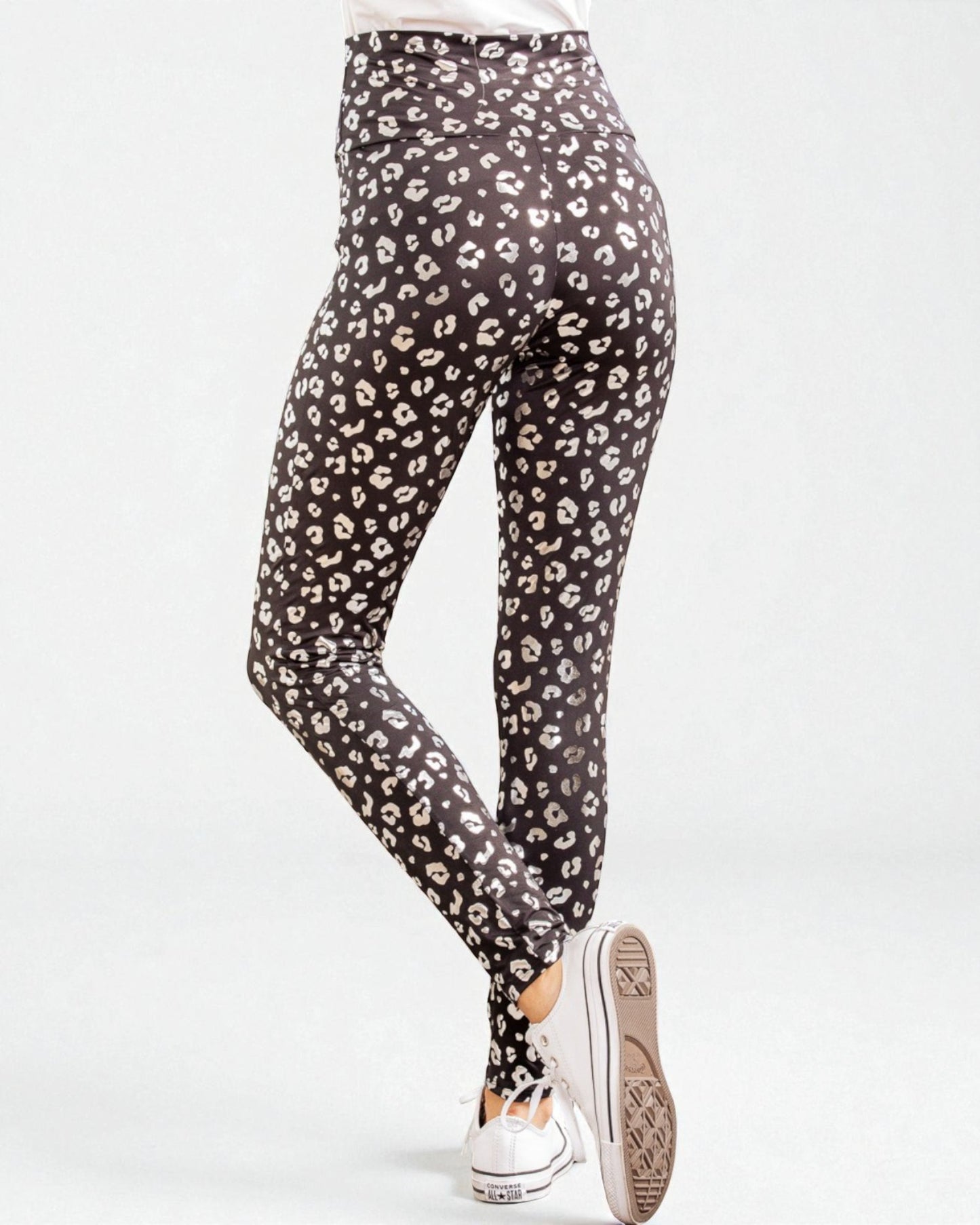 Black leggings with white leopard print worn by a person on a white background