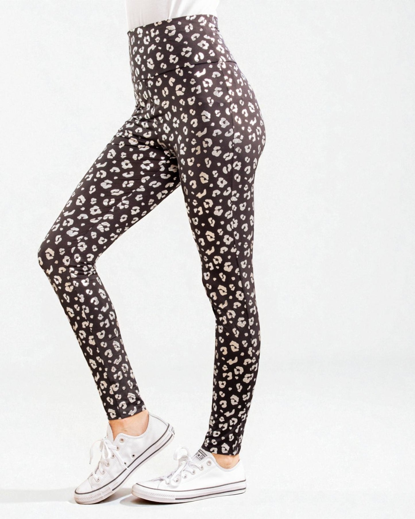 Black leggings with white leopard print worn by a person on a white background