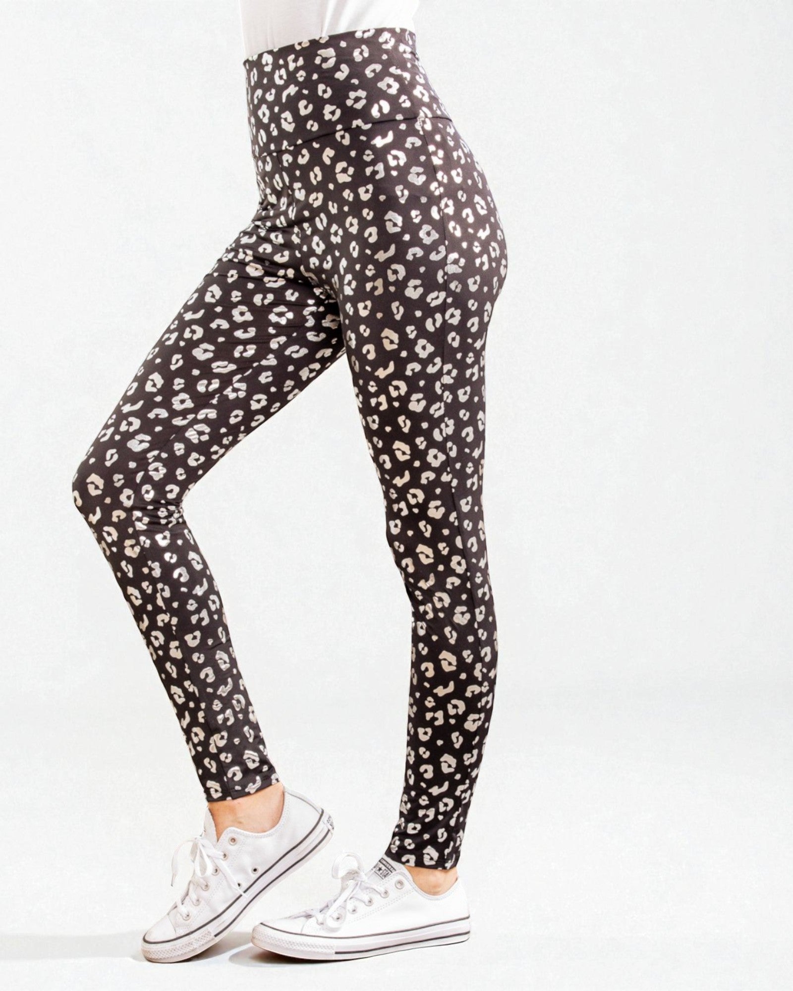 Black leggings with white leopard print worn by a person on a white background