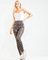 Woman wearing a white top and patterned leggings on a white background