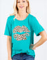 Woman wearing a teal t-shirt with a leopard print graphic on a white background