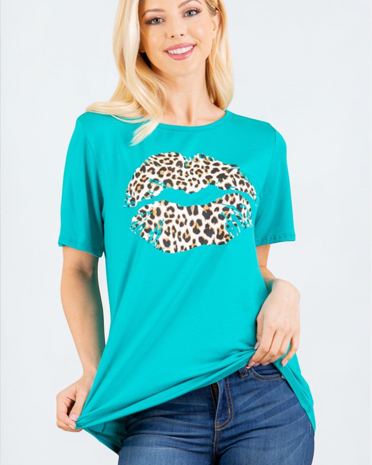 Woman wearing a turquoise t-shirt with a leopard print lip design on a white background