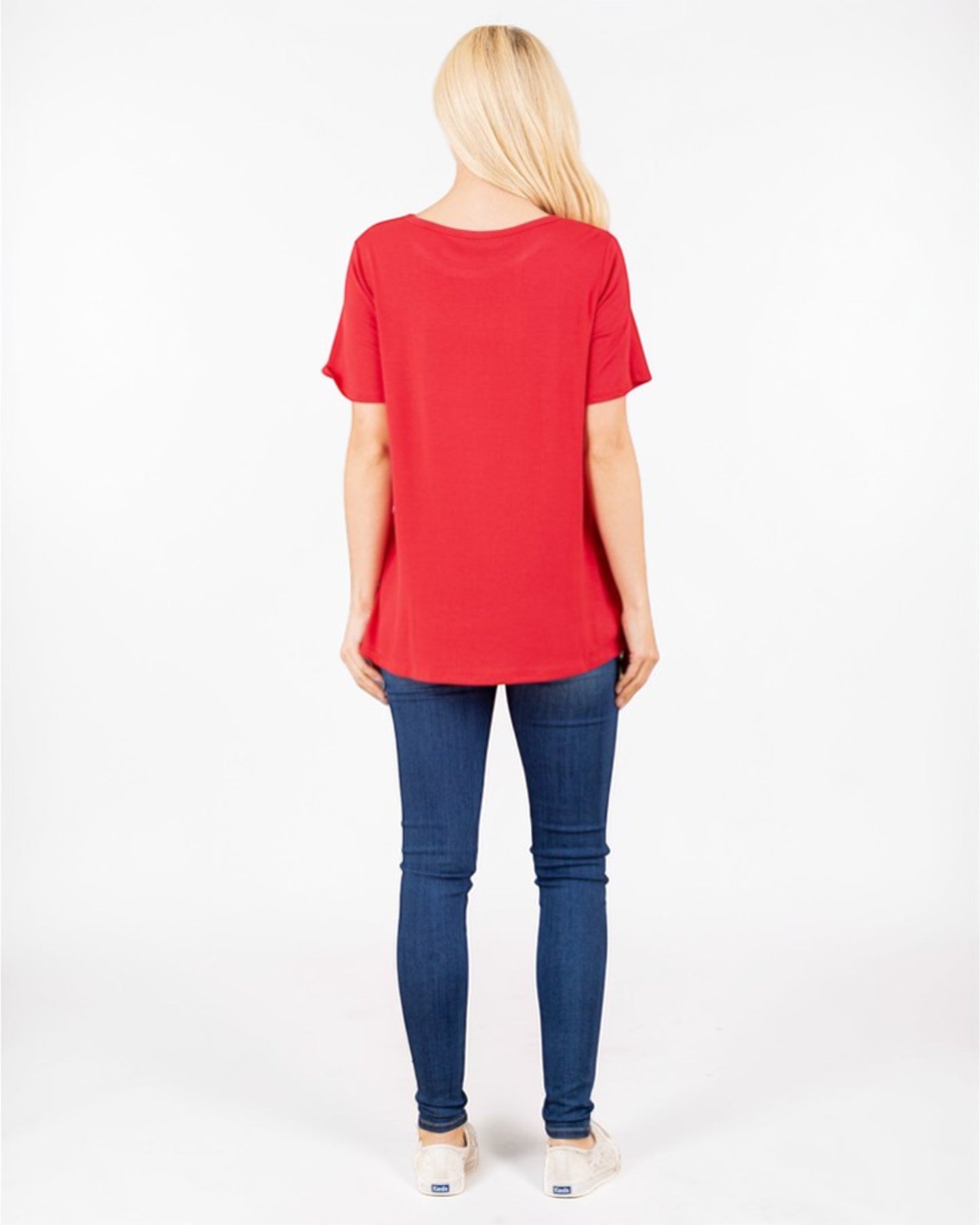Person wearing a red t-shirt and blue jeans on a white background