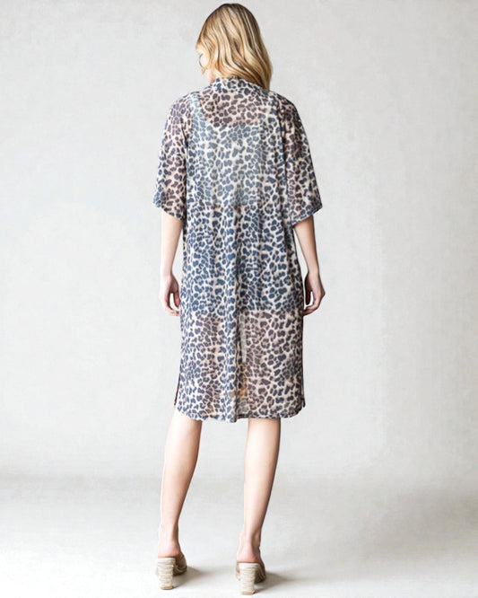 Woman wearing a leopard print dress against a plain background