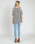 Woman wearing a leopard print top and light blue jeans on a white background