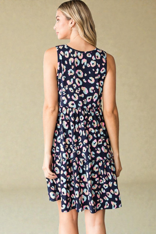 Woman wearing a navy dress with multicolor leopard print on a beige background