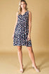 Woman wearing a navy floral dress against a beige background