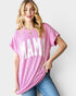 Woman wearing a pink oversized t-shirt with 'MAMA' printed on it against a plain background