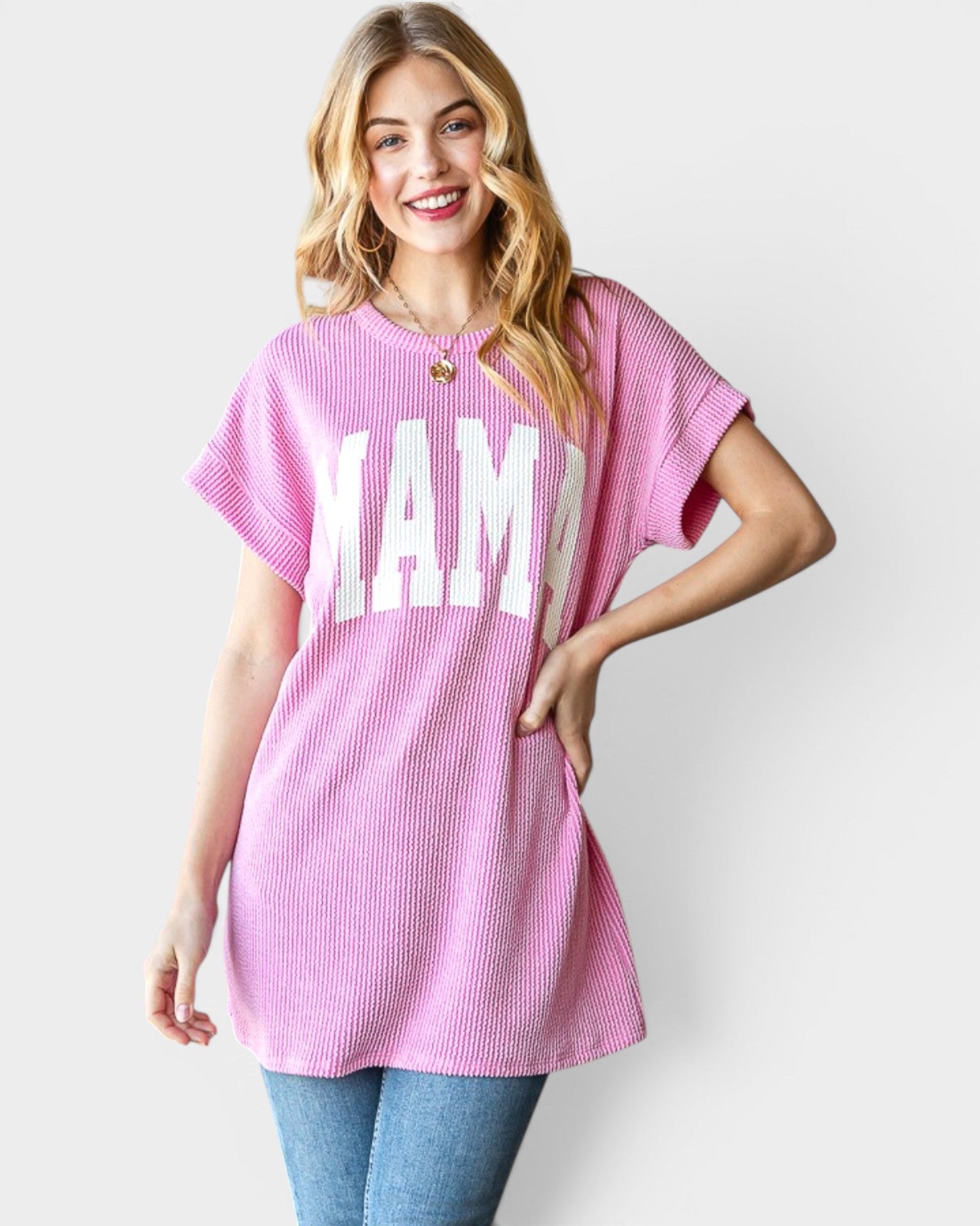 Woman wearing a pink tunic with 'MAMA' printed on it against a white background