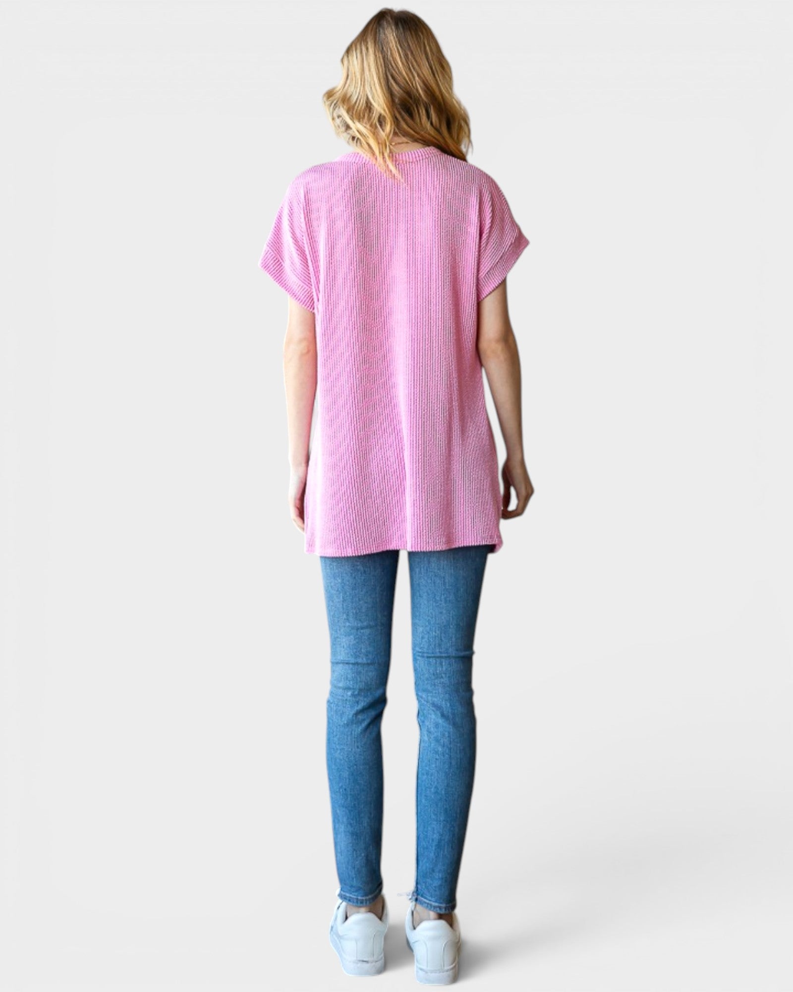 Person wearing a pink t-shirt and blue jeans on a white background