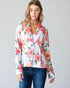 Woman wearing a floral jacket with a plain background