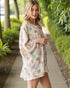 Woman wearing a floral dress walking along a path in a garden.