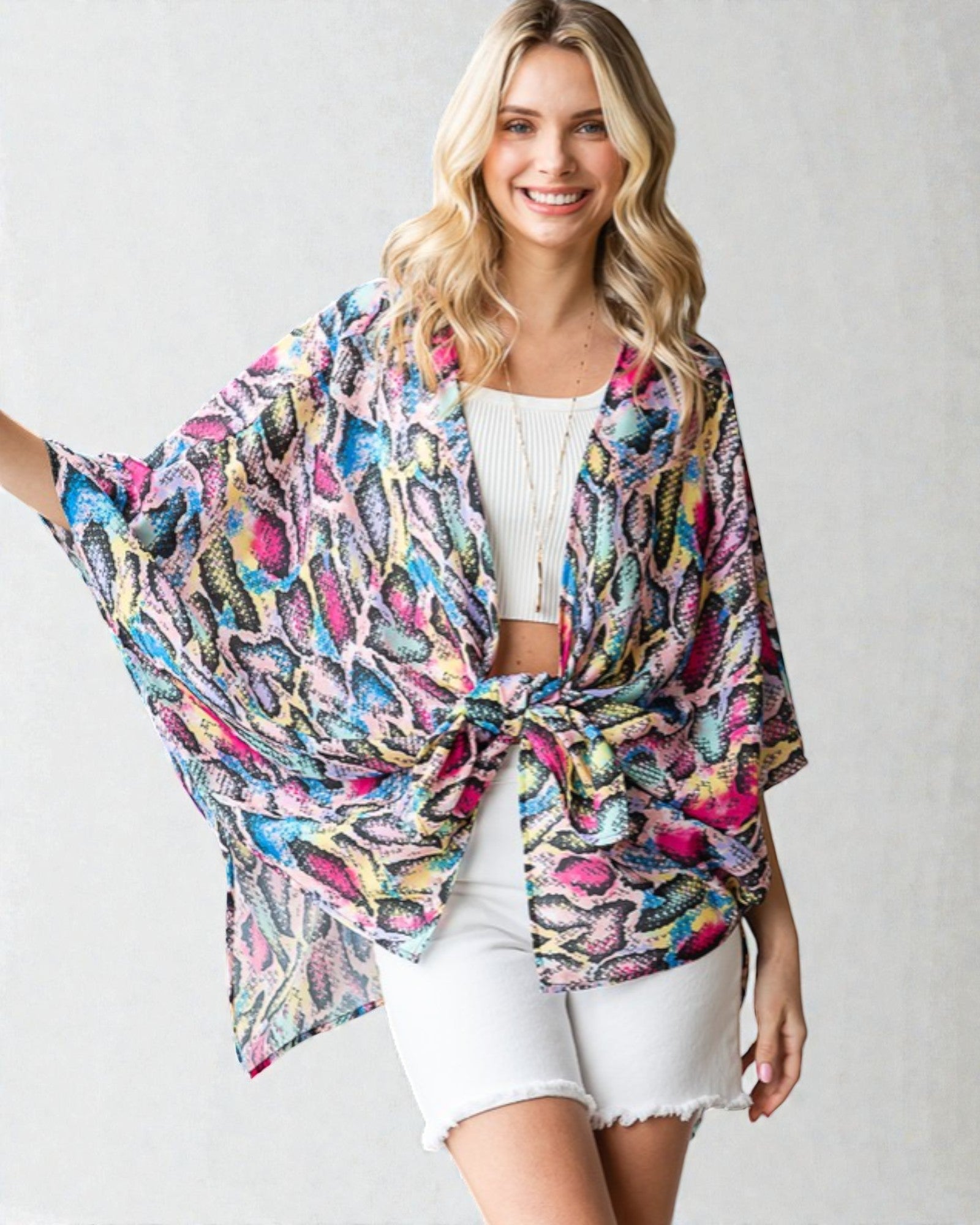 Woman wearing a colorful kimono-style garment against a plain background
