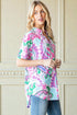 Woman wearing a colorful patterned shirt against a neutral wall