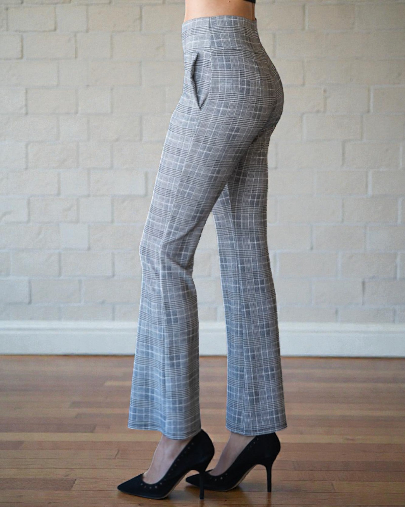 Person wearing gray checkered pants with a neutral background