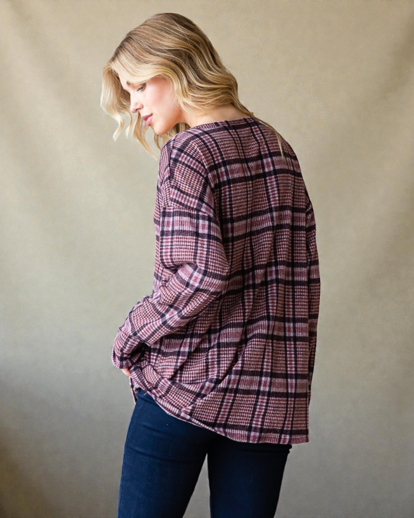 Woman wearing a plaid shirt against a plain background
