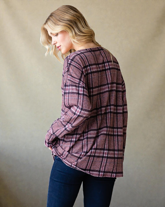 Woman wearing a plaid shirt against a plain background