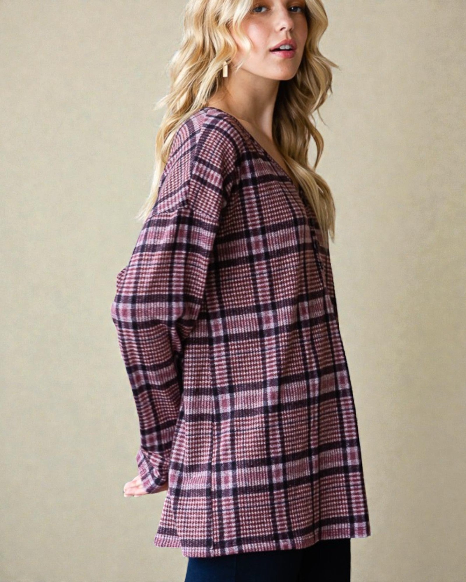 Woman wearing a plaid shirt against a beige background