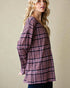 Woman wearing a plaid shirt against a beige background