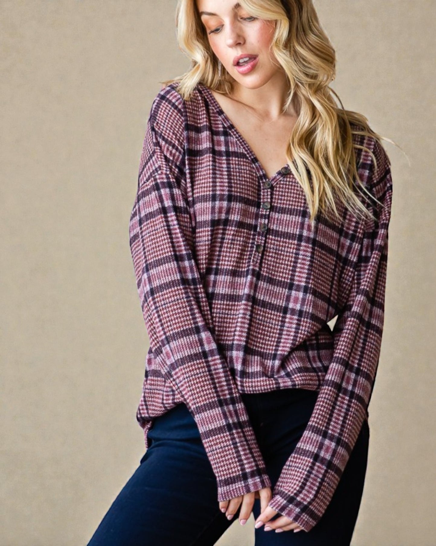 Woman wearing a plaid shirt against a beige background