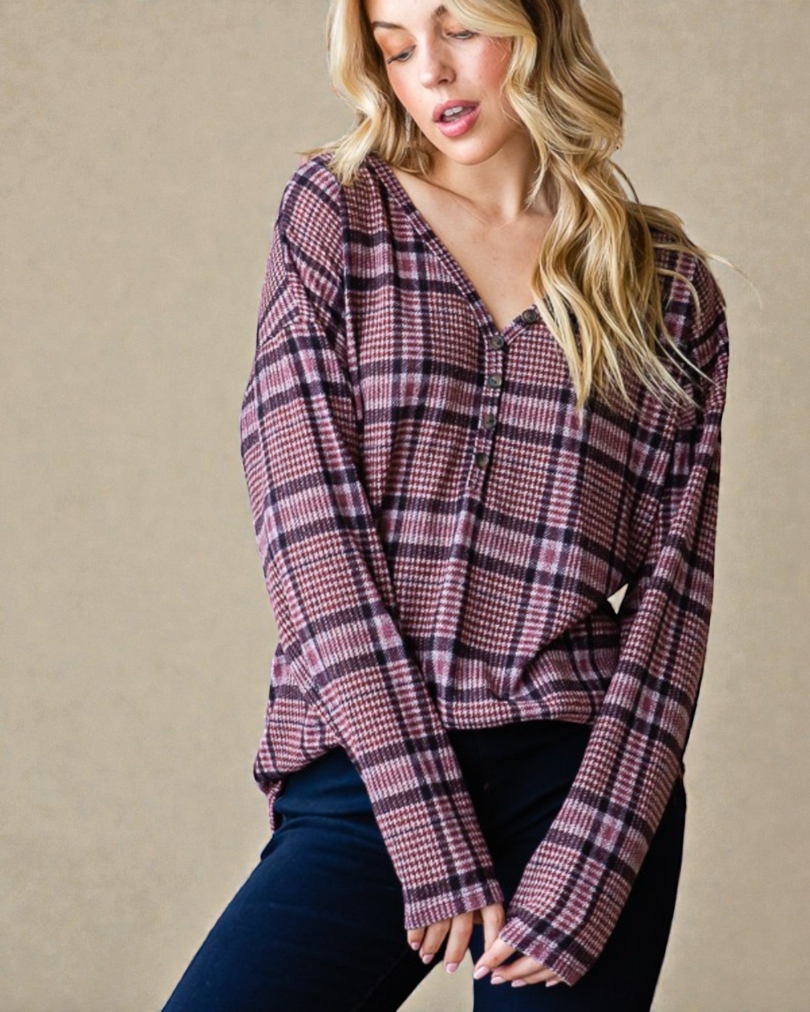 Woman wearing a plaid shirt against a beige background