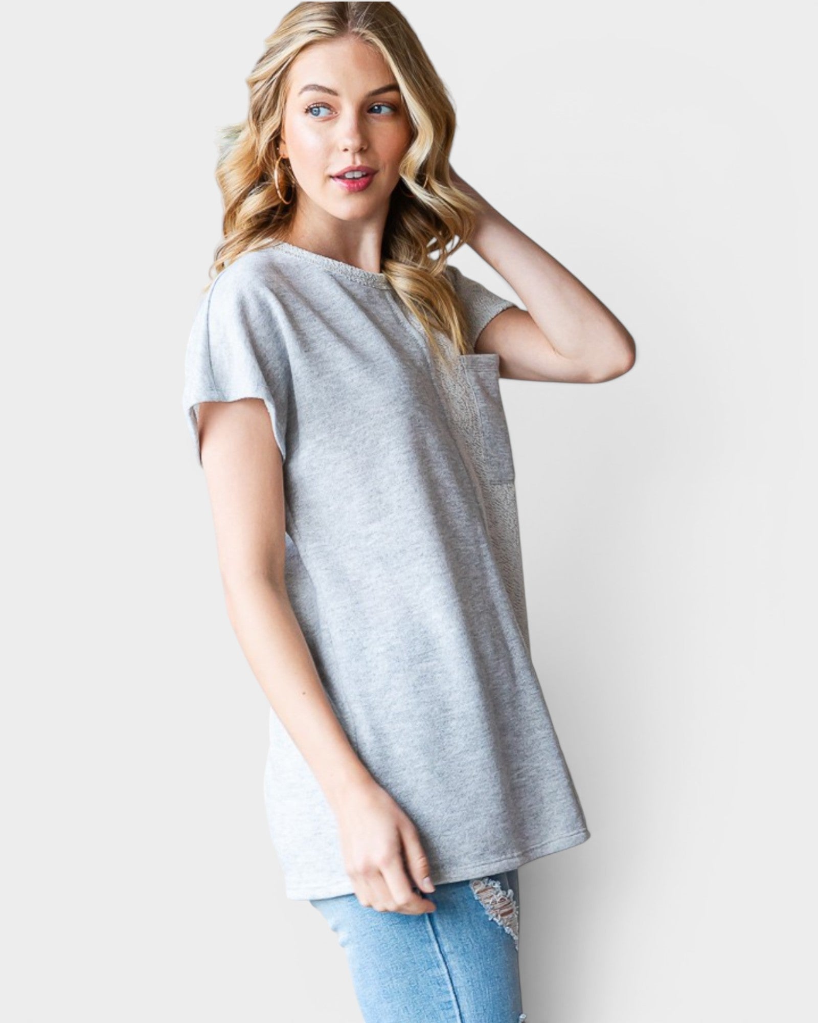 Woman wearing a gray t-shirt and blue jeans on a white background