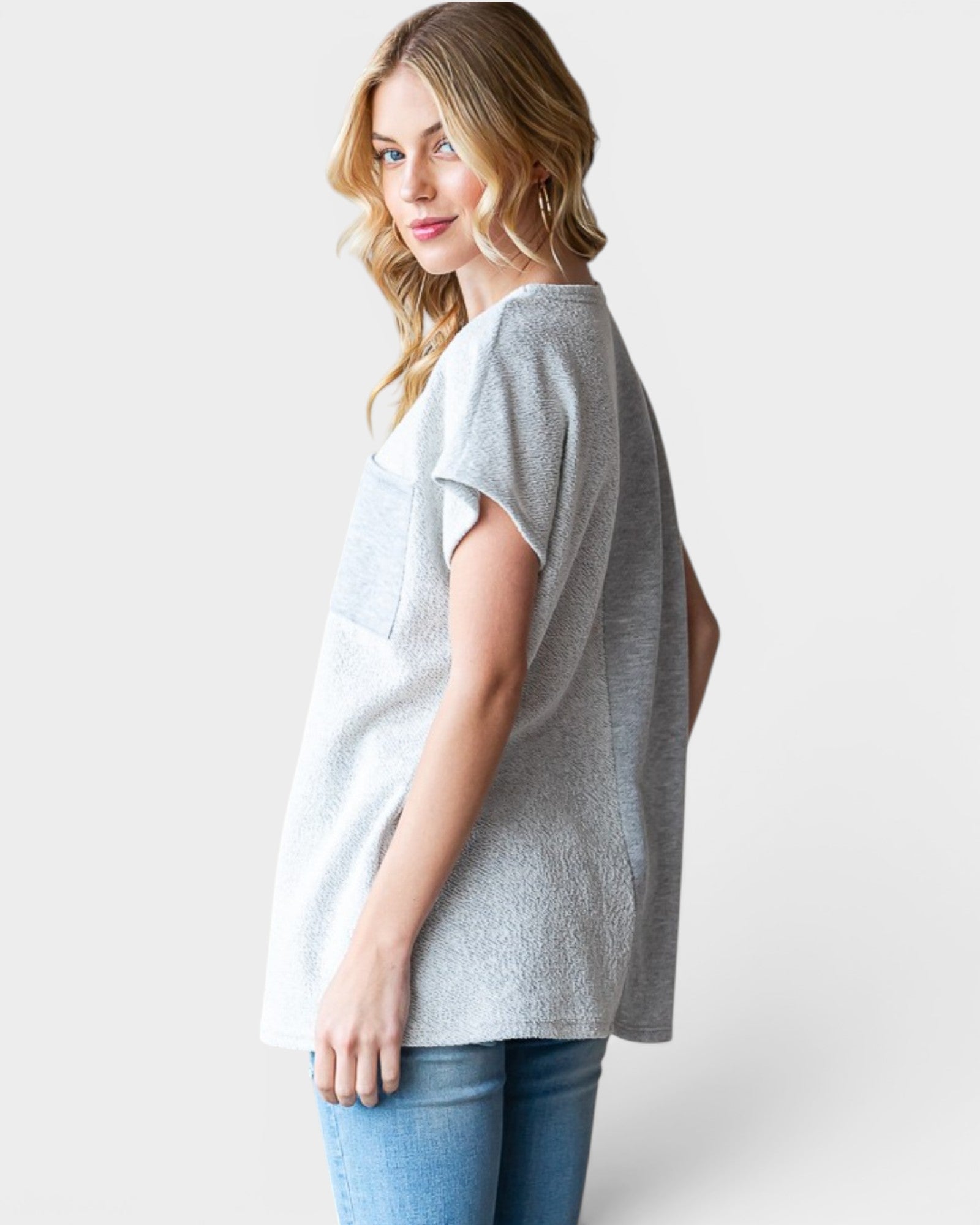 Woman wearing a gray t-shirt and blue jeans on a white background