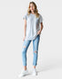 Woman wearing a gray t-shirt and light blue ripped jeans on a white background