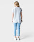 Person wearing a light gray t-shirt and blue jeans on a white background