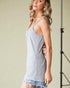 Woman wearing a light blue ribbed tank top against a neutral background