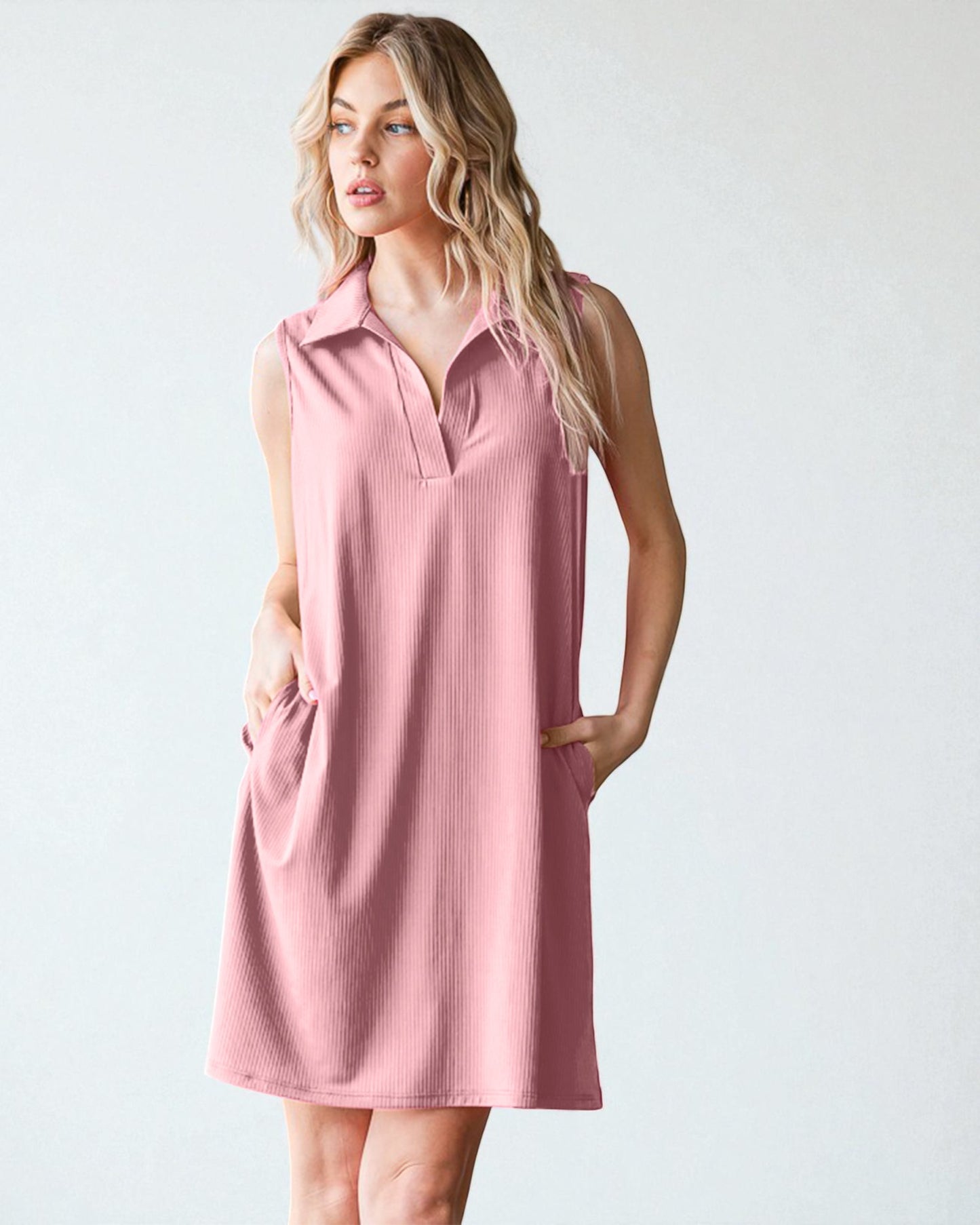 Woman wearing a pink sleeveless dress against a white background