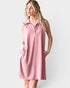 Woman wearing a pink sleeveless dress with a collar on a white background