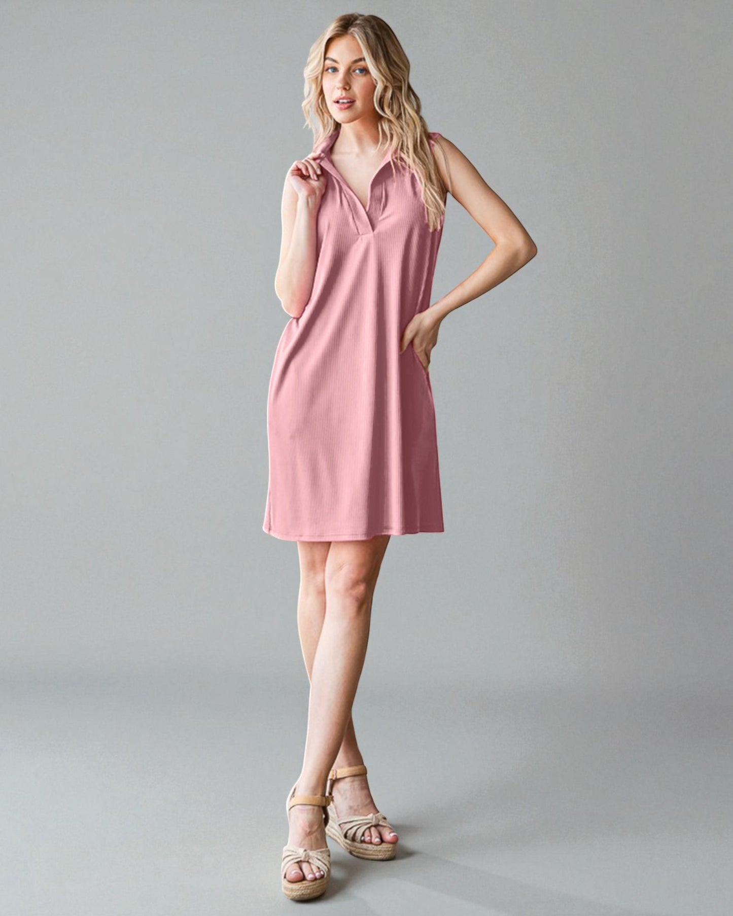 Woman wearing a pink dress against a gray background