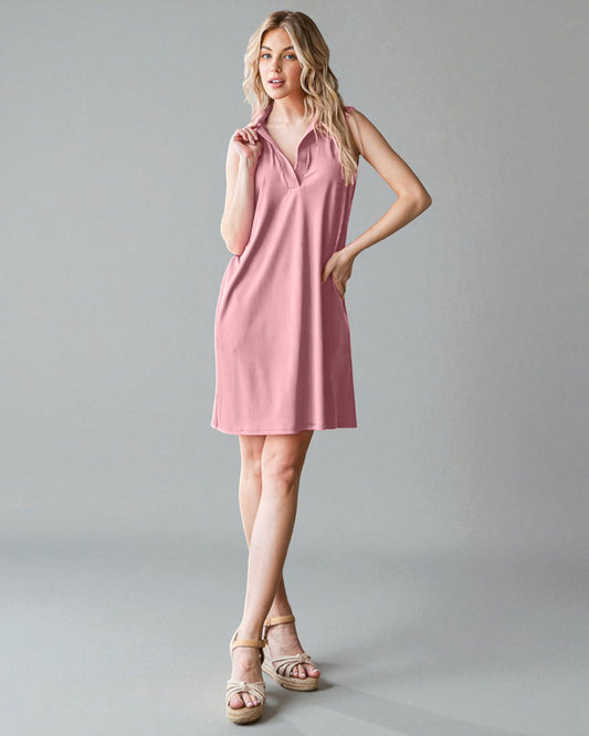 Woman wearing a pink dress against a gray background