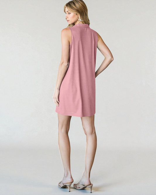 Woman wearing a pink sleeveless dress on a plain background