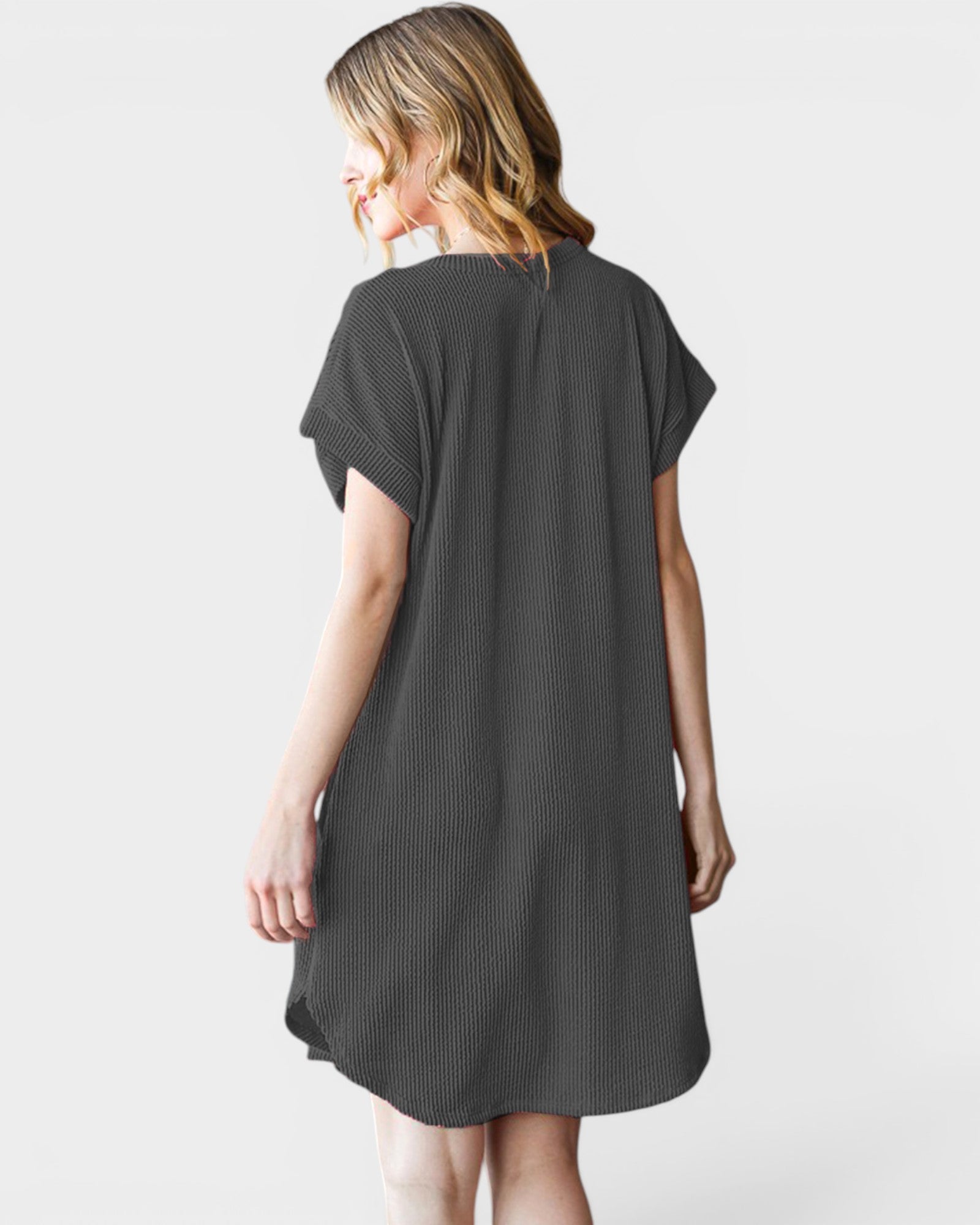 Woman wearing a dark gray t-shirt dress on a white background